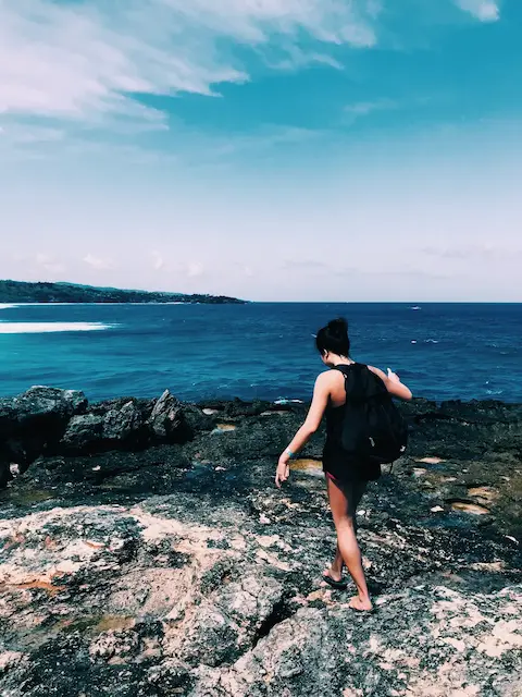 my partner walking along a rock feature alongside the ocean